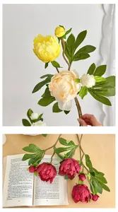 Dettaglio di peonie artificiali in seta gialla e rossa per decorazioni d'interni