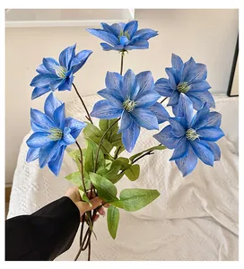 Dettaglio di fiori di clematide blu artificiali con texture 3D e foglie verdi