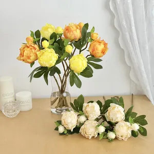 Peonie artificiali in seta gialla e bianco crema in un vaso di vetro per decoro casa