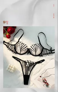 Detail of sheer two-piece lingerie set with black leaf patterns on white faux fur