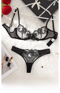 Ensemble de lingerie en dentelle noire avec roses rouges et perles sur fond de fausse fourrure