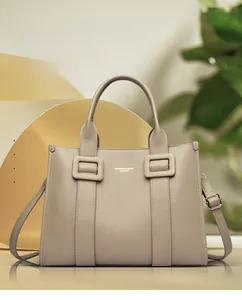 Detail van beige imitatielederen draagtas met fijne lycheetextuur en metalen gesp