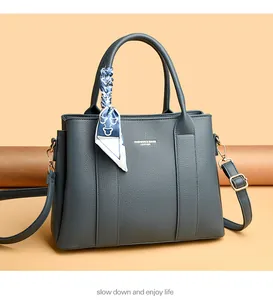 Close-up of pebble leather handbag with silk scarf handle and adjustable strap