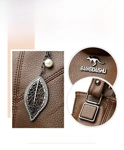 Close-up of brown pebbled leather texture with leaf pendant and kangaroo brand plate
