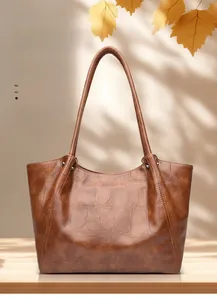 Detailed view of brown crocodile texture leather tote with sleek shoulder straps
