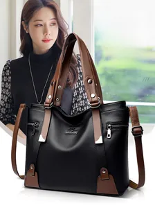 Close-up of black lychee grain leather tote with brown handles and silver metallic hardware
