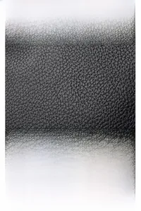 Detailed macro view of black litchi grain leather texture and silver kangaroo logo hardware