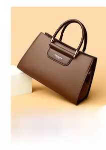 Détail de la texture cuir grainé marron et des finitions dorées du sac à main chic