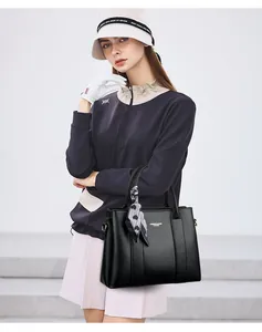 Close-up of black lychee grain leather handbag featuring decorative heart pattern silk scarf