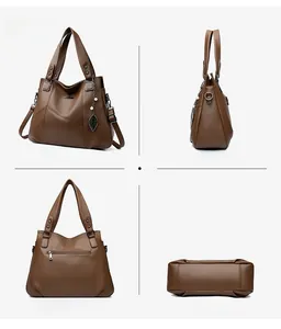 Detail of brown leather tote showing textured finish, kangaroo logo and pearl pendant