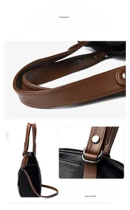 Detail of reinforced leather handles and polished metal hardware on bicolor satchel