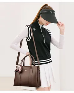 Detailed shot of dark brown lychee leather handbag with decorative silk scarf on handle