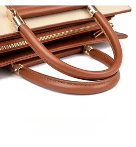 Vue détaillée de la poignée du sac en cuir avec boucles dorées et coutures précises