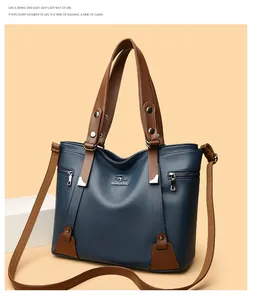 Detailed view of blue pebbled leather tote with silver kangaroo logo and brown strap
