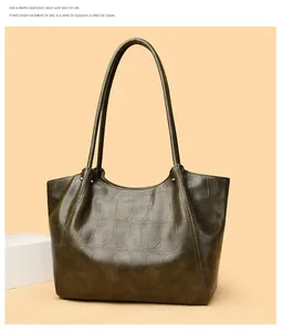 Detail of dark olive green tote bag featuring crocodile embossed leather and fixed strap