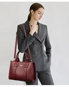 Detail van de bordeauxrode lederen handtas met lychee-textuur en schouderband