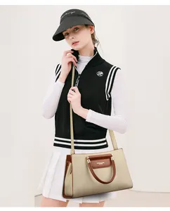 Sac à main en cuir beige avec poignées marron porté à l'épaule par un mannequin