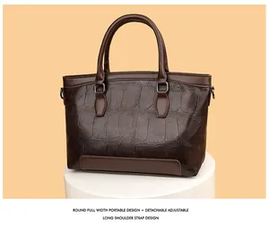 Detailed view of the dark brown croc-embossed leather tote with sturdy round handles