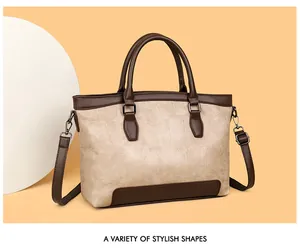 Detail of stone-pattern leather tote bag showing beige body and brown contrast handles