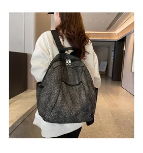 Detail view of denim backpack with star pattern, durable zippers and wide shoulder straps