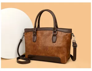 Detail of vintage crocodile pattern leather tote with adjustable shoulder strap and handles