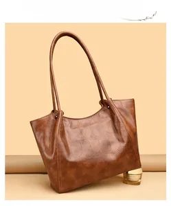 Close-up of brown crocodile texture leather tote bag with fine stitching detail