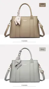 Detail of elegant leather texture and gold hardware on apricot and grey handbags
