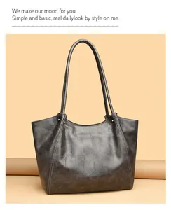 Detailed macro view of dark grey crocodile embossed faux leather texture on tote bag