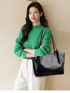 Detail of black crocodile texture tote bag with slim shoulder straps for women