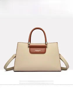 Détail du sac cabas en cuir abricot et marron avec ferrures dorées et lettrage chic