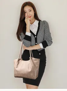 Detail view of champagne gold stone pattern tote bag carried by model in casual outfit