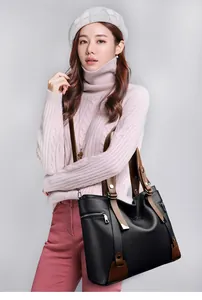Detail of black pebbled leather tote bag with brown straps for stylish commuting
