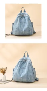 Detail of light blue denim backpack showing triangular design and side pockets