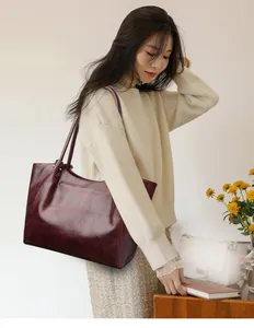 Detailed view of burgundy crocodile pattern leather tote bag with elegant pleated design