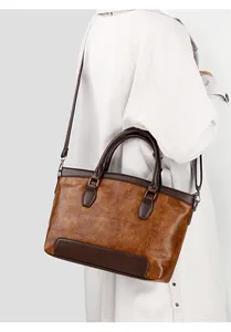 Detail of vintage brown crocodile embossed leather tote bag with crossbody strap