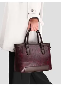 Detailed close-up of burgundy crocodile pattern leather and dark brown handles