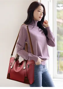 Detail of red leather tote bag with kangaroo logo and adjustable shoulder strap