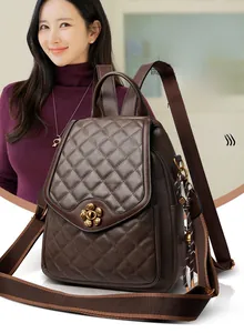 Detail of dark brown quilted backpack featuring a gold flower clasp and woven strap