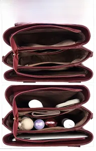 Detail view of burgundy leather handbag interior with multi-compartment storage and lining