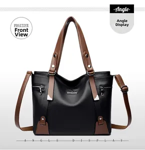Front view detail of a black pebbled leather tote bag with brown handles and logo