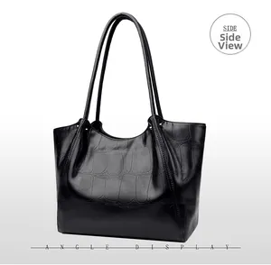 Side view of black crocodile pattern leather tote bag showing fine texture and sleek handles