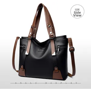 Side view of black textured leather tote bag with brown straps and brand logo detail