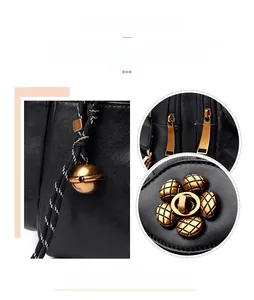 Detail of floral twist lock and golden hardware on black quilted leather backpack
