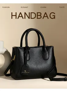 Macro detail of black lychee grain leather handbag with gold kangaroo charm and hardware