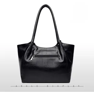Detailed view of the back of a black crocodile pattern tote bag with zip pocket