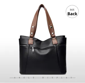 Detail view of the back of black pebble leather handbag featuring a silver zip pocket