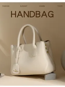 Detail of beige pebbled leather handbag with gold metal studs and kangaroo logo pendant