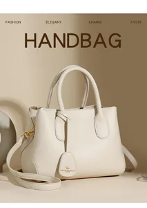 Close-up of creamy white lychee grain leather handbag with gold kangaroo charm and hardware