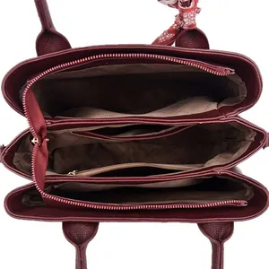 Burgundy pebbled leather handbag with triple compartments and a plaid silk scarf