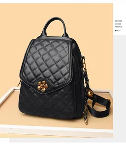 Detail of black quilted leather backpack with vintage gold flower buckle and bell charm